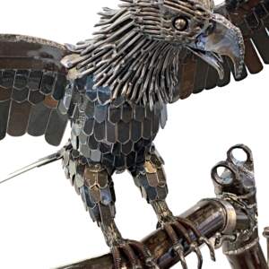 Reclaimed metal sculpture of a bald eagle landing on a tree sculpture by Wendy Stone.