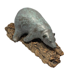 Mixed media sculpture by Karin Taylor of a friendly bear sleeping on a piece of driftwood.