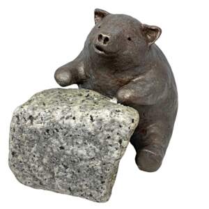 Mixed media sculpture of a bear sitting at a rock desk by Karin Taylor.