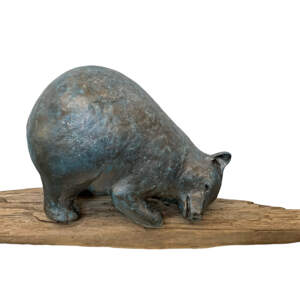 Original mixed media sculpture of a cute friendly bear resting with one ear on the ground on a piece of driftwood by Karin Taylor.