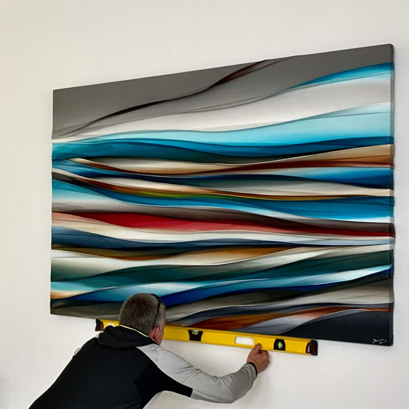 Trent installing a beautiful large Melanie Giguere painting in a client's home | Effusion Art Gallery in Invermere, BC