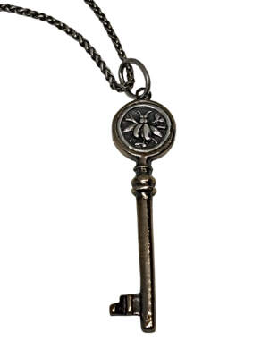 Handmade bronze and sterling silver bee key pendant by Karyn Chopik Jewelry at Effusion Art Gallery in Invermere, BC.