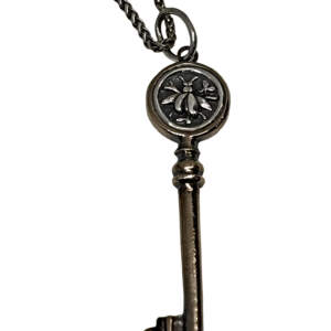 Handmade bronze and sterling silver bee key pendant by Karyn Chopik Jewelry at Effusion Art Gallery in Invermere, BC.